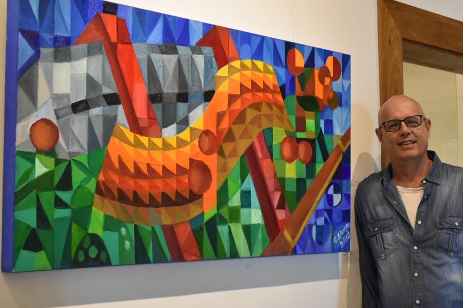 Autor e artista plástico George Alonso ao lado de uma de suas obras